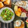 Overhead view of a variety of serving platters with food demonstrating various methods of how to keep the food cold and fresh in the outdoor setting